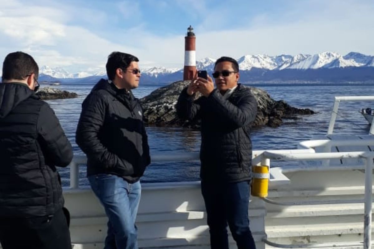 Personas sacando foto con Faro detras